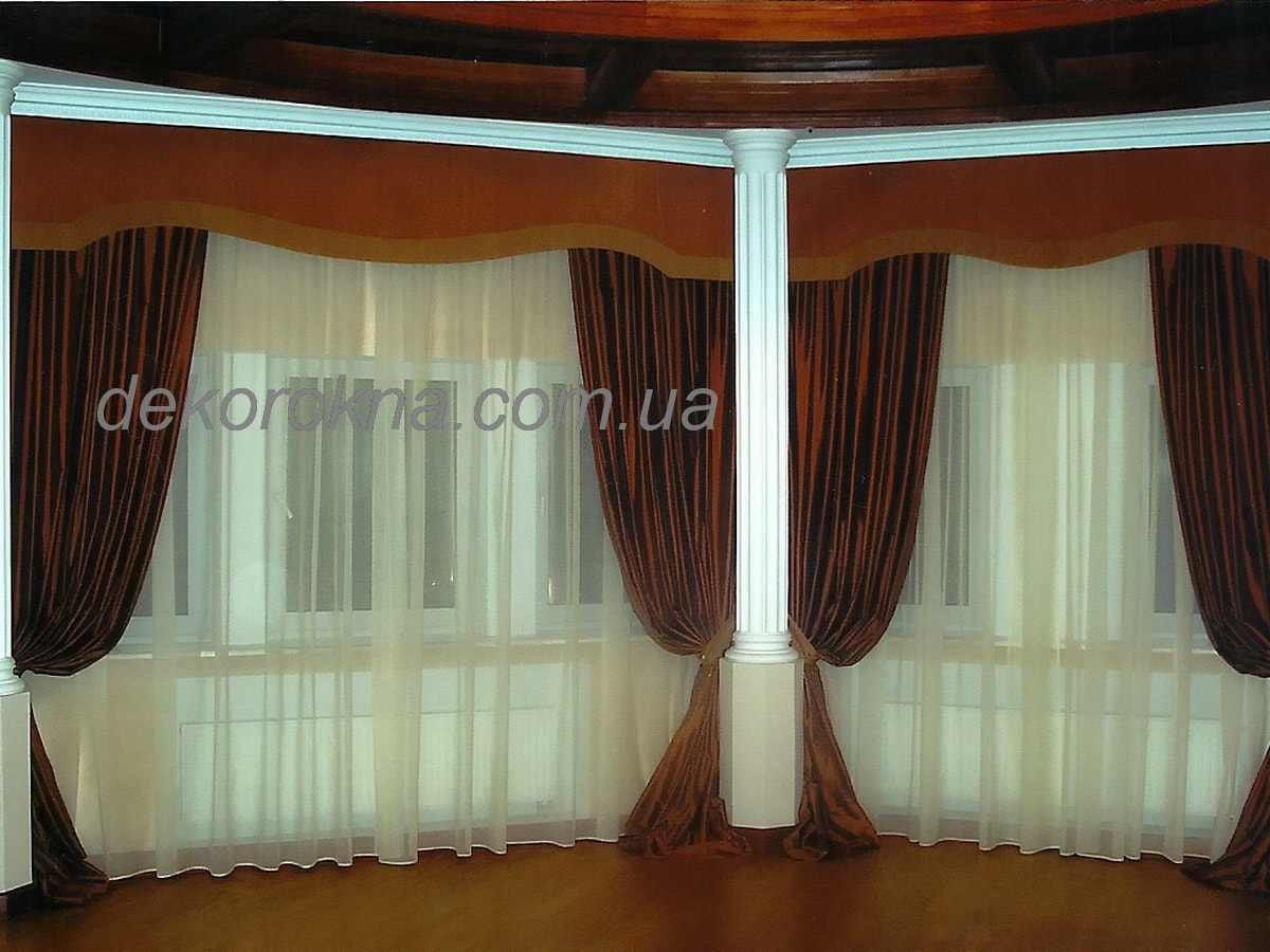 На шторах используется однотонный коричневый шелк. Жесткий ламбрекен пошит из шелка более светлого оттенка и украшен кантом.